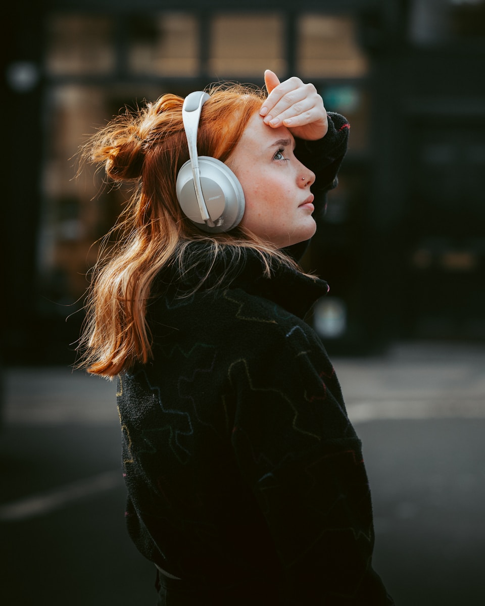 A woman wearing headphones standing on the street